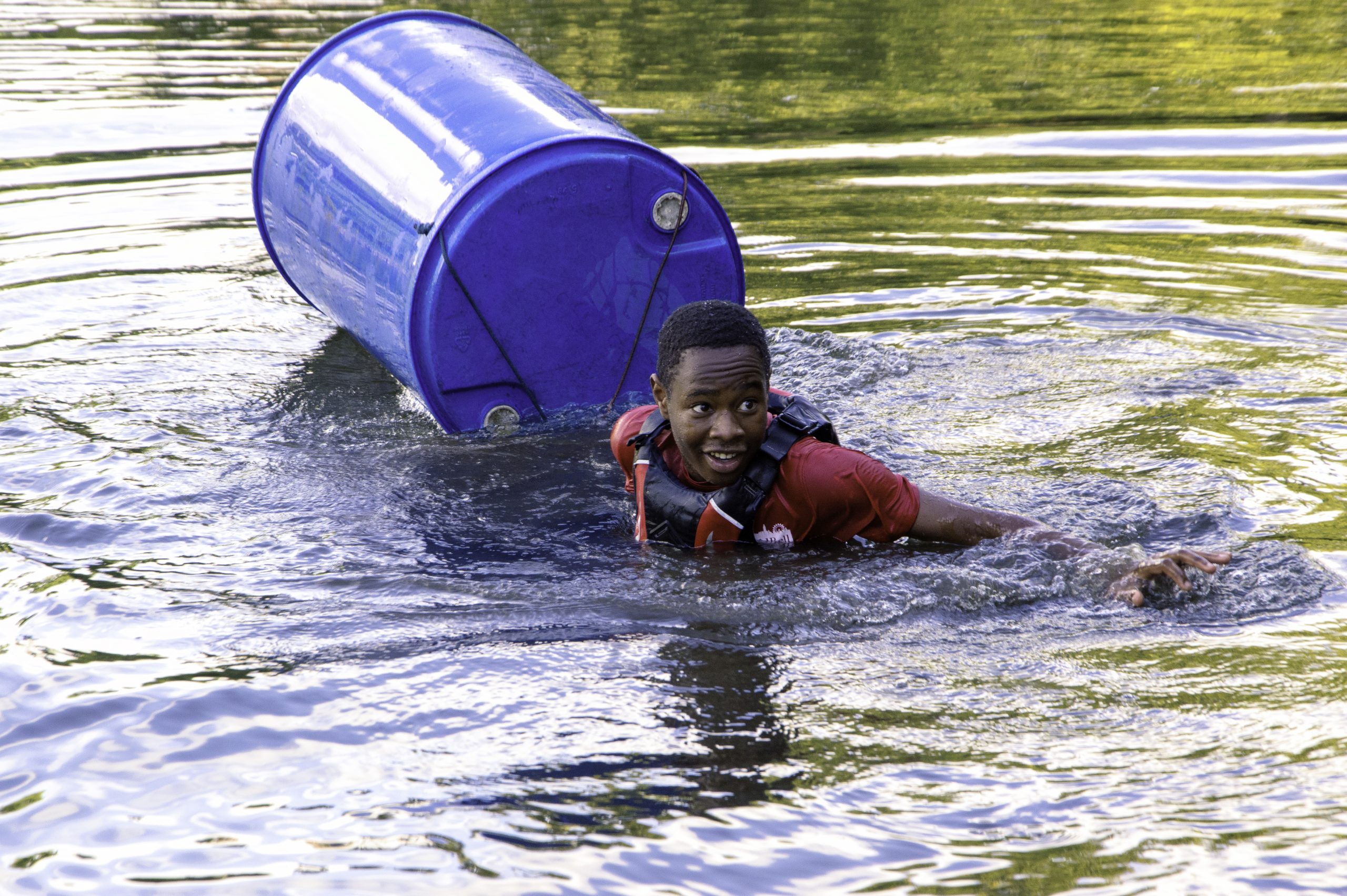 A cadet swimming in water due to the makeshift raft breaking