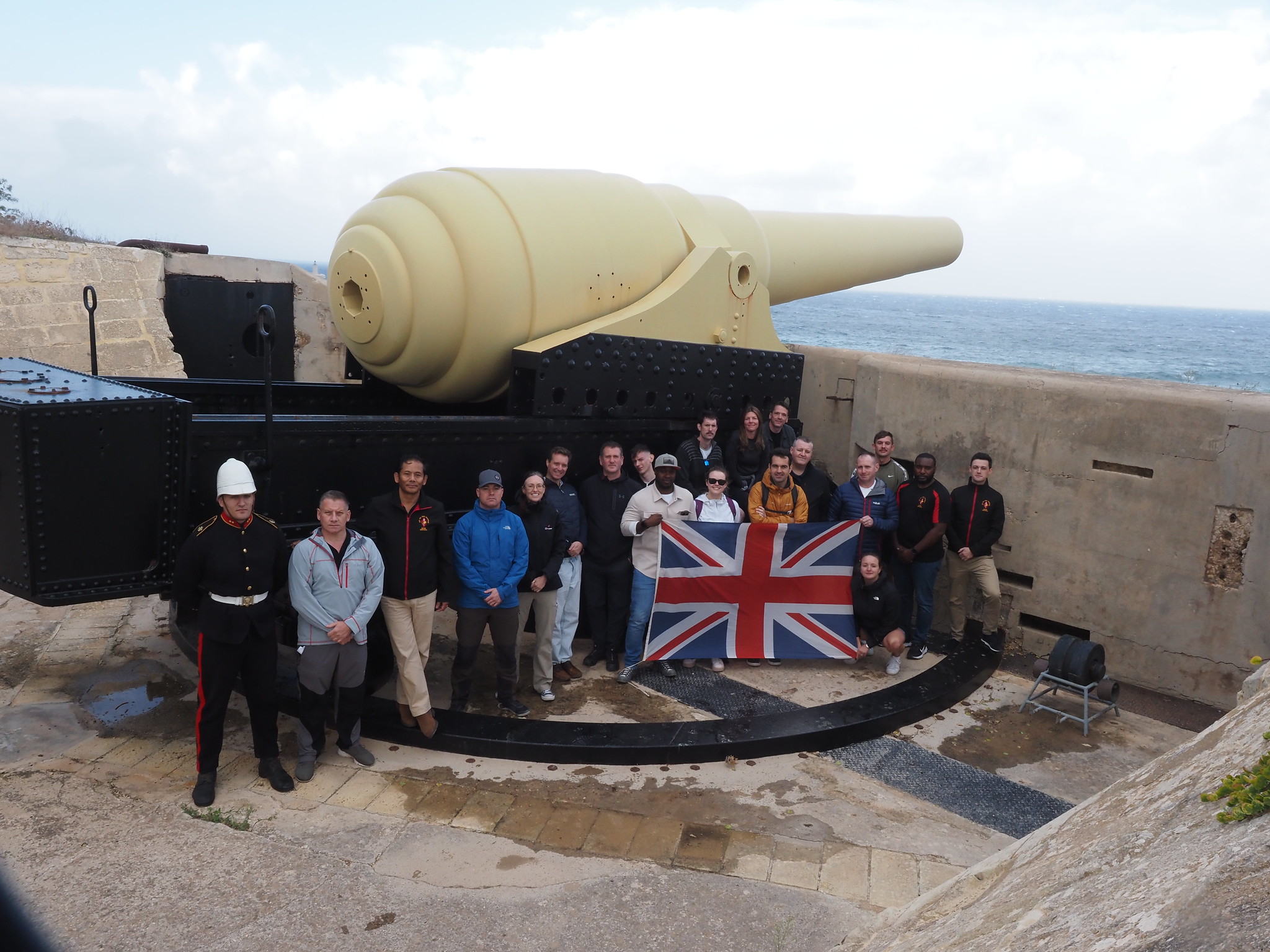 The group in front of large white canon