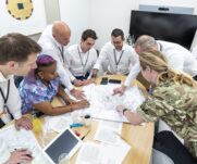 Reservist helping employees from an organisation team during the 3MI Intelligence Challenge