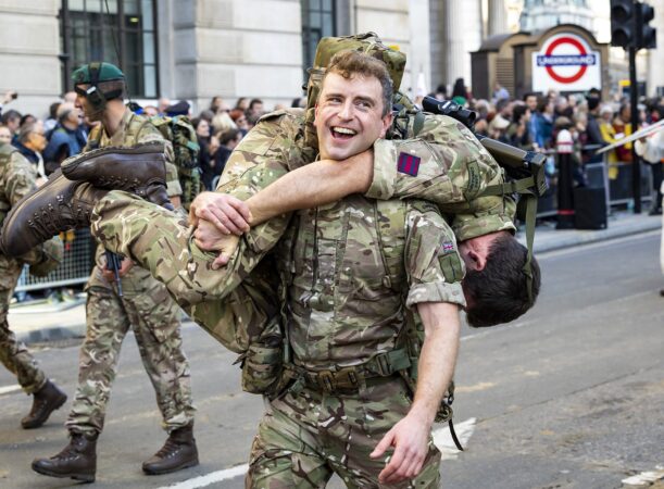 A soldier carrying his teammate on his shoulder during the Lord Mayor's Show 2022