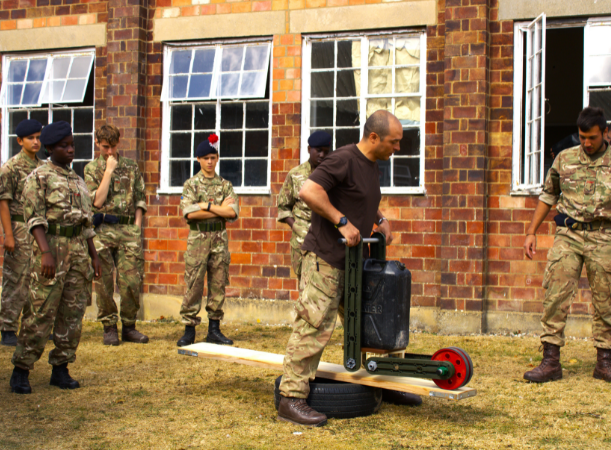 An adult volunteer guiding cadets through an exercise at an Annual Camp