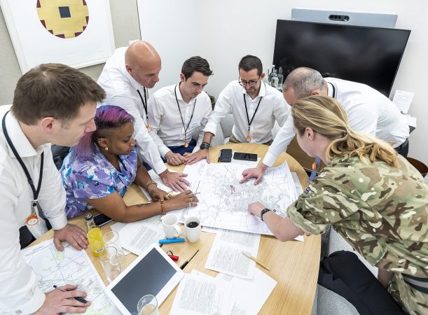 Reservist helping employees from an organisation team during the 3MI Intelligence Challenge
