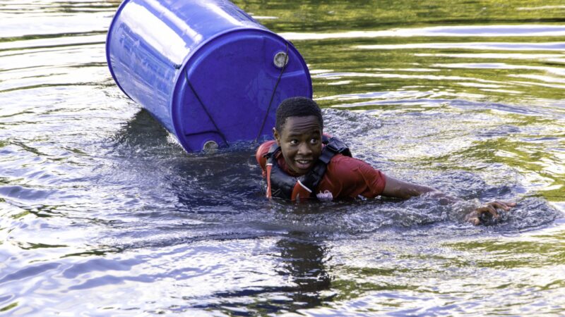 A cadet swimming in water due to the makeshift raft breaking