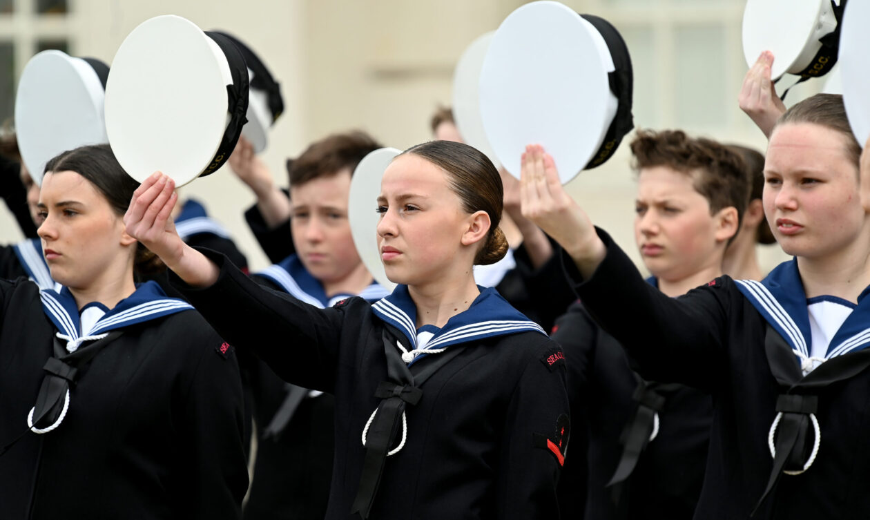 Sea Cadets holding their hats as a sign of respect for the king